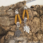 zoom sur boucles d'oreilles en liège jaune natura avec la breloque en guise de feuille en métal