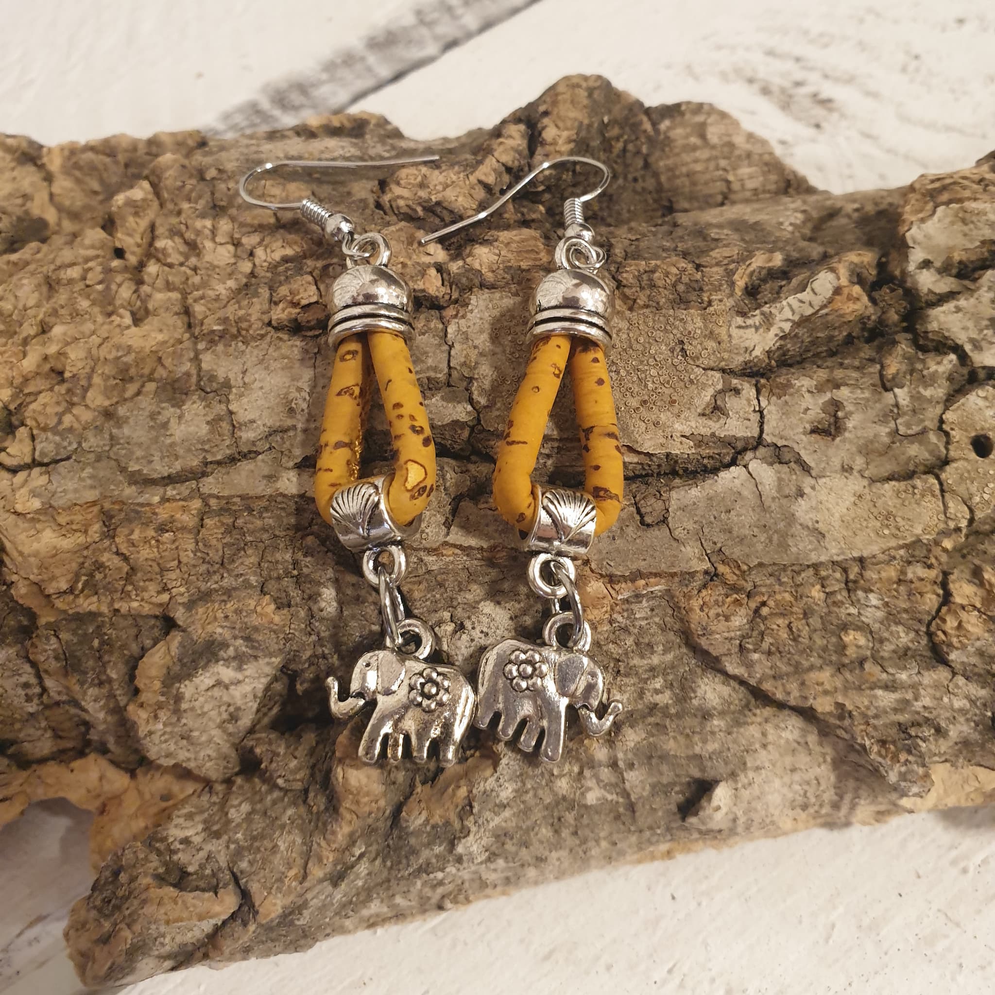 Détail des boucles d’oreilles jaune en liège avec éléphant