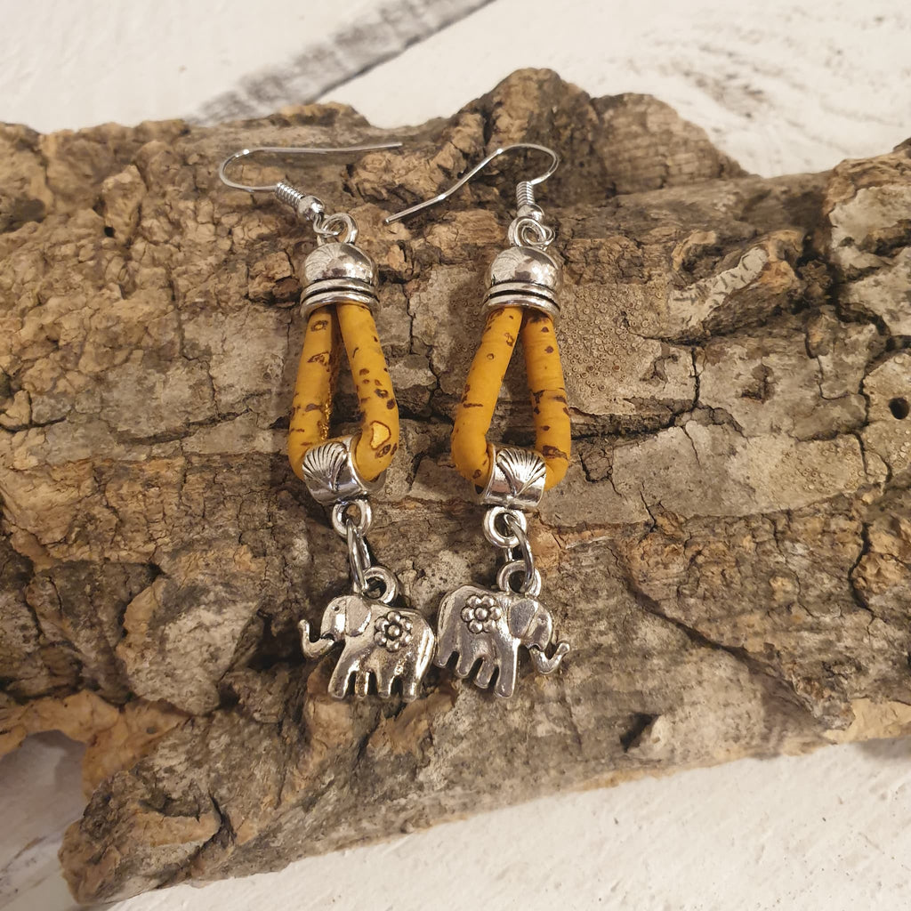 Détail des boucles d’oreilles jaune en liège avec éléphant