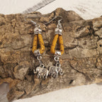 Détail des boucles d’oreilles jaune en liège avec éléphant