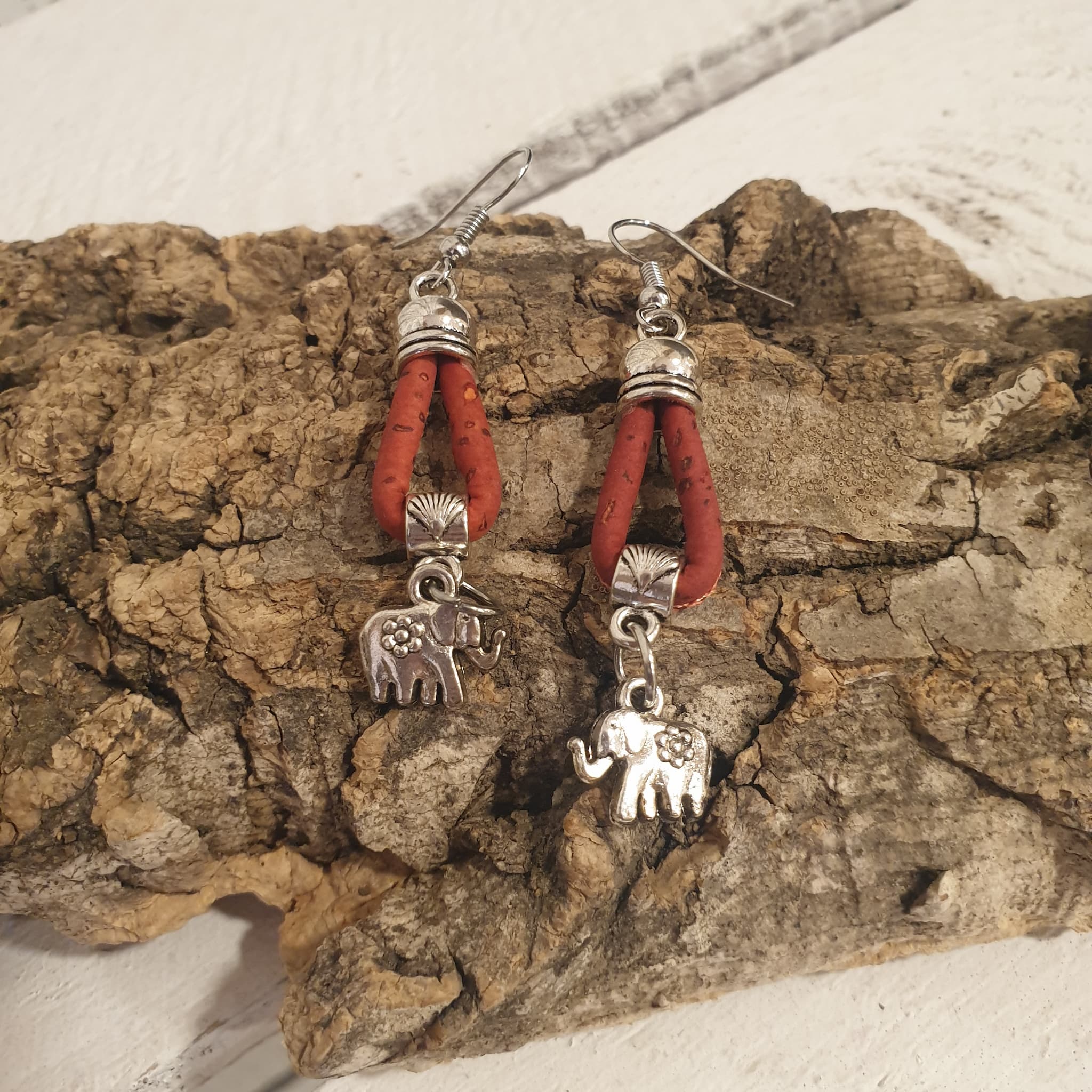 Détail des boucles d’oreilles  rouge en liège avec éléphant