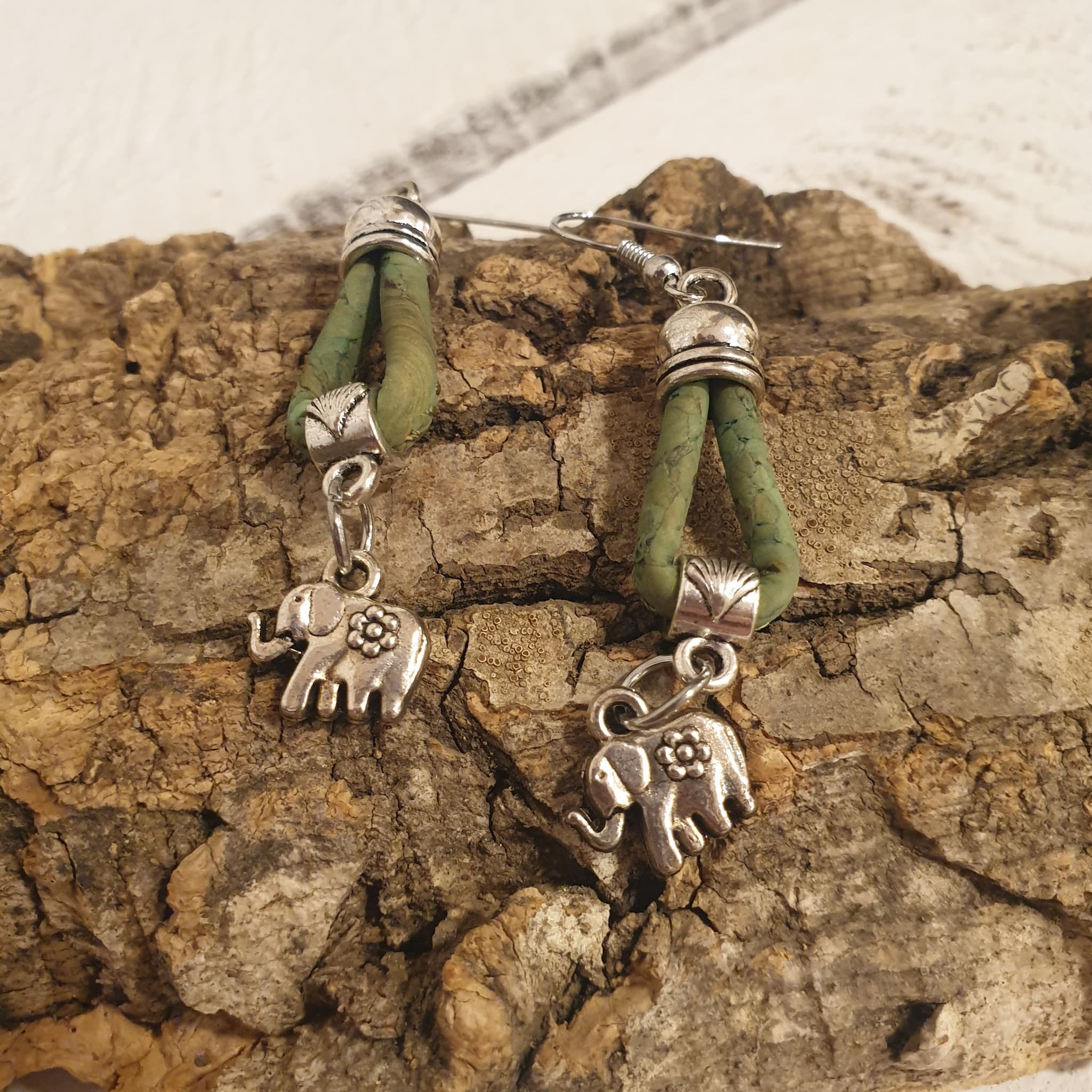 Détail des boucles d’oreilles  vert en liège avec éléphant