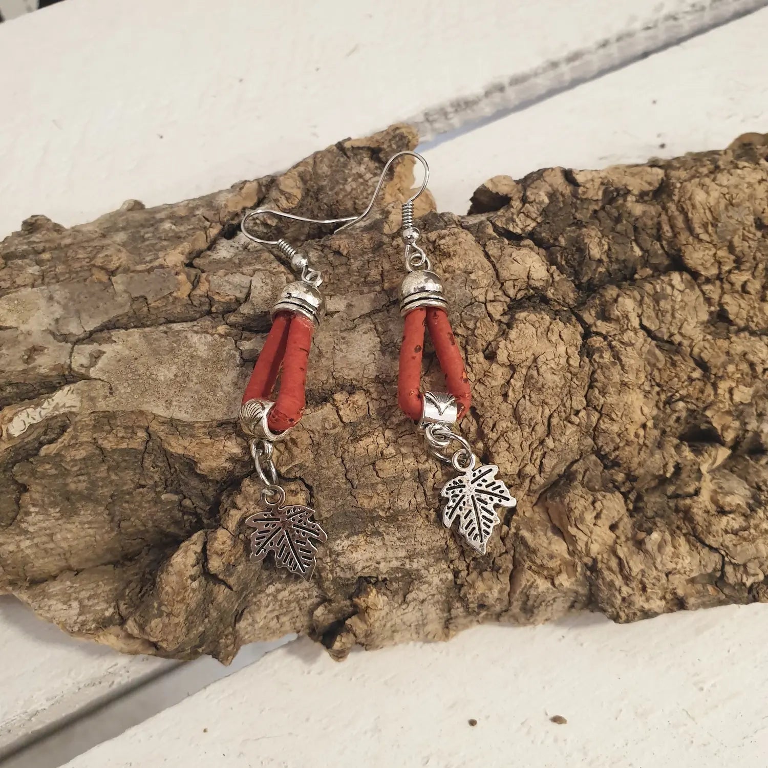 boucles d'oreilles en liège rouge natura avec une petite feuille en métal comme breloque