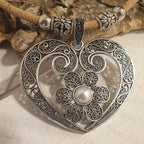 Détail du pendentif cœur avec fleur et perle centrale